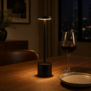 GlowHaven Lumi cordless table lamp in black glowing on a dining table