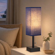 Bedside table lamp with blue fabric shade in a Scandinavian bedroom