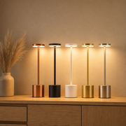 Lumi cordless lamps in rose gold, black, white, gold and silver on a sideboard